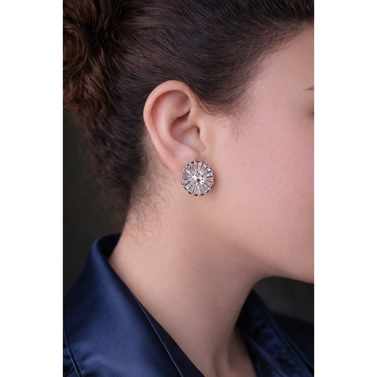Silver sunburst crystal stud earrings worn by model, round crystal center with baguette halo design shown in high-definition close-up.