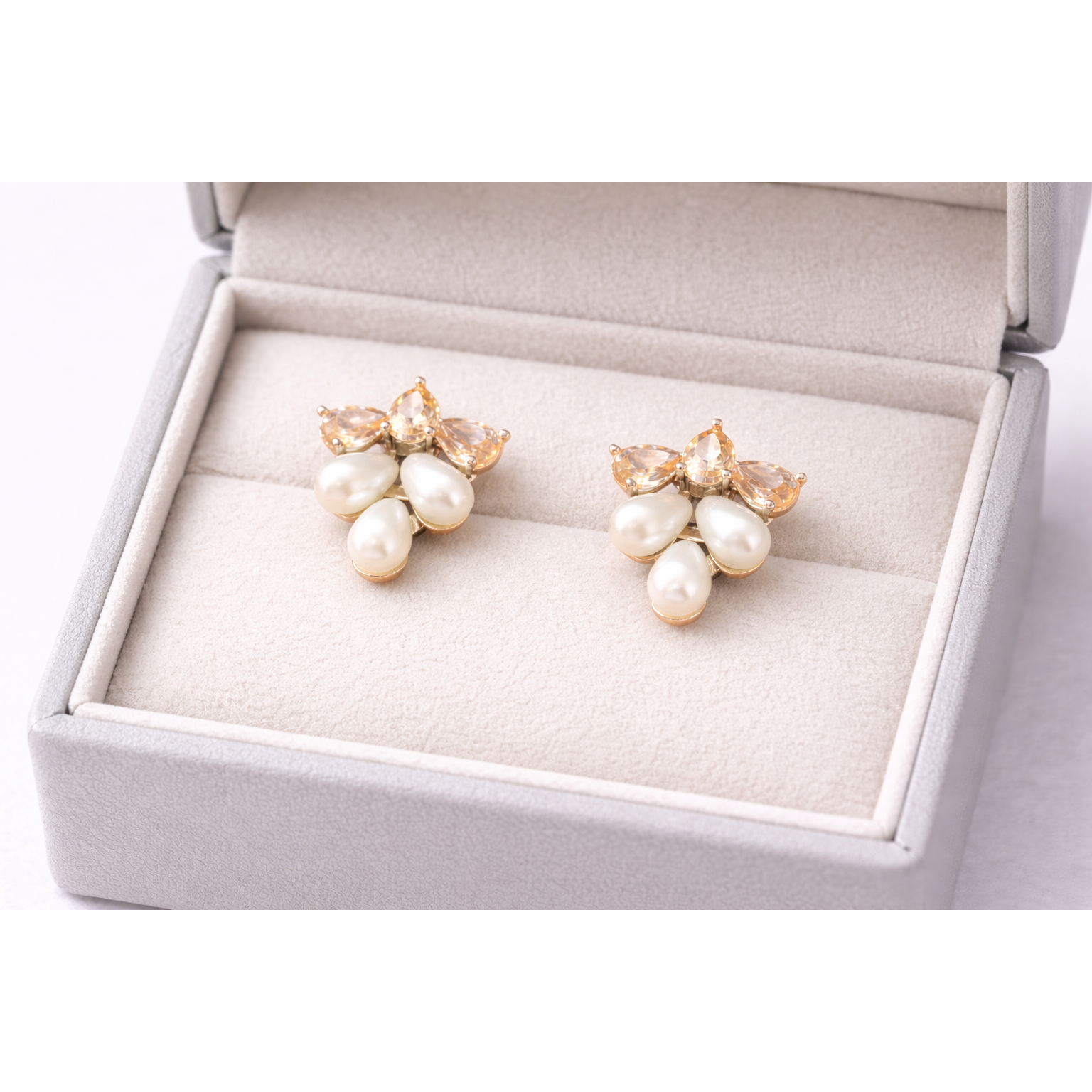 Creamy pearl cluster stud earrings displayed in a light grey jewellery box, studio-lit close-up showing accurate colours and details.