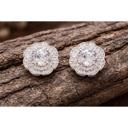 Silver floral halo crystal stud earrings with clear stones placed on natural wooden texture background