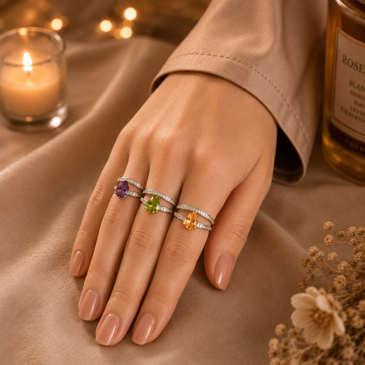 Model wearing three silver split-band rings with purple, green, and peach pear-cut crystal stones in a luxury lifestyle setting by TIAS Collection