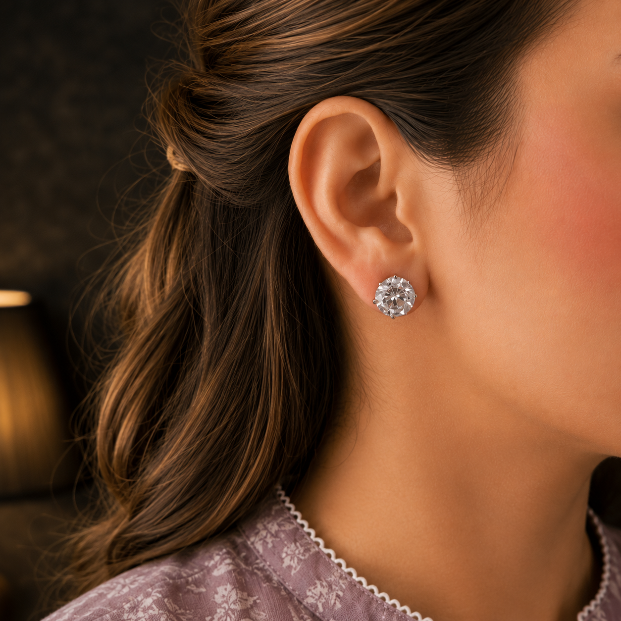 Woman wearing classic round solitaire crystal stud earrings with a mauve printed linen shirt in a close-up portrait.