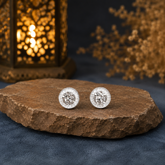 Round mosaic crystal stud earrings displayed on a premium brown natural stone over slate blue suede with a softly blurred lantern background.