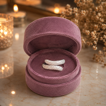 Silver twisted pavé wrap ring with shimmering micro-set stones displayed in a premium mauve velvet jewellery box on a luxury marble surface