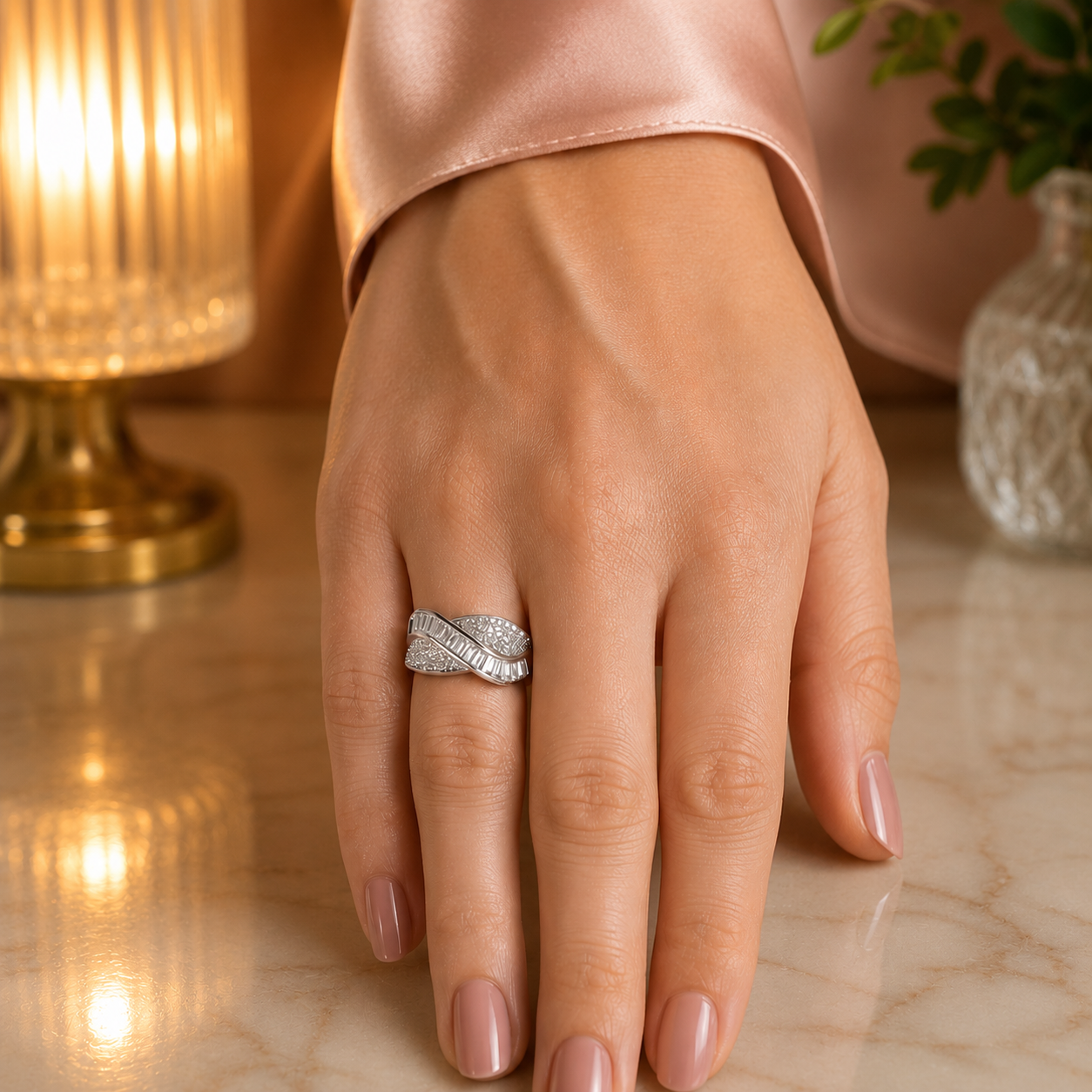 Elegant silver wave crystal statement ring worn on a hand with tea pink silk sleeve in a premium luxury lifestyle setting