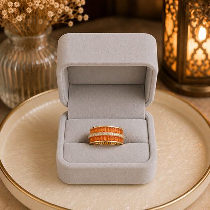 Wide interwoven crystal statement band ring displayed in a premium light grey velvet jewellery box on a pearlized cream tray with warm ambient lantern lighting.