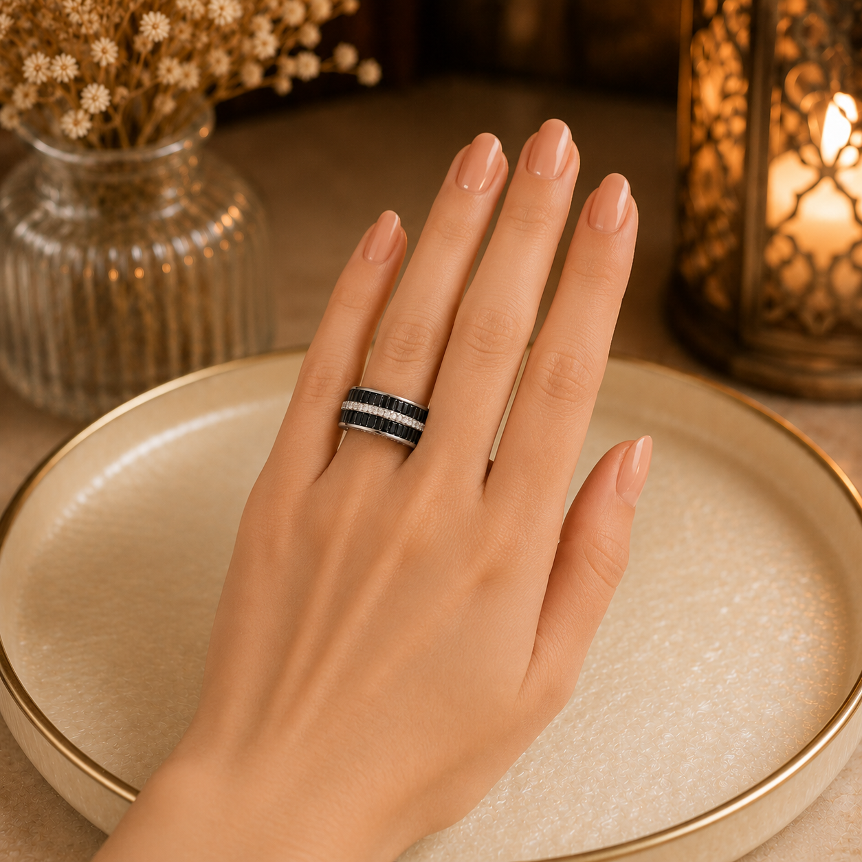 Model wearing a wide interwoven crystal band ring with sparkling zircon detailing on a manicured hand against a warm luxury setting