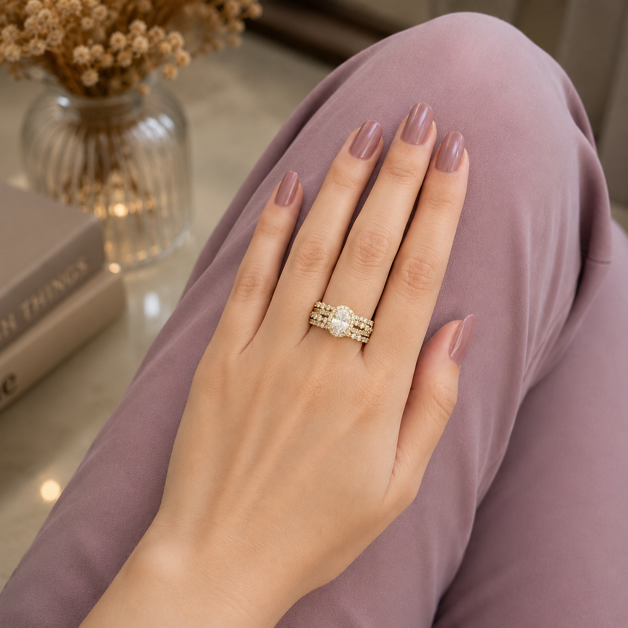 Gold-tone oval halo zircon statement ring worn on a hand with a soft mauve outfit, highlighting its triple-row sparkling band.