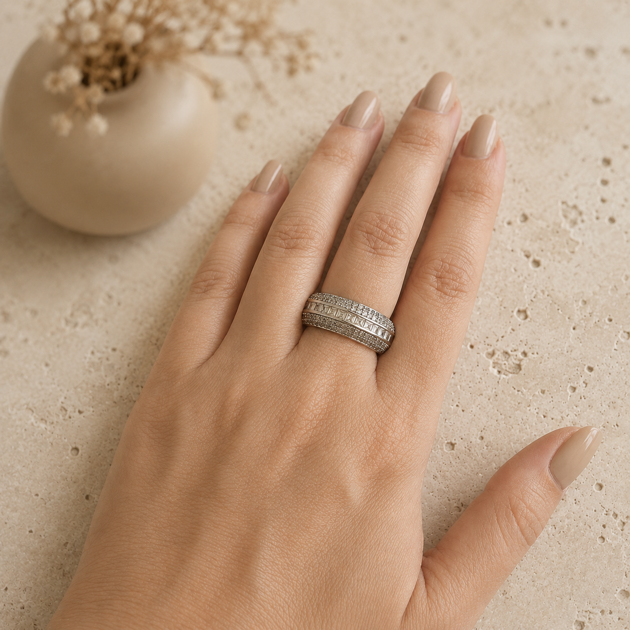Premium silver-tone statement band ring featuring princess-cut channel-set stones with sparkling pavé detailing, displayed on a model's hand 