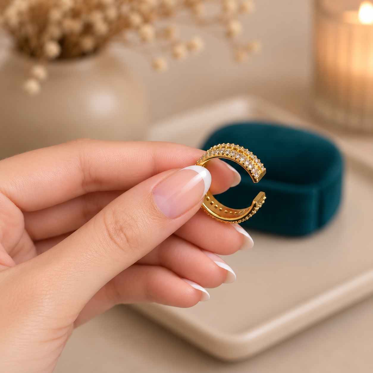 Close-up of a gold adjustable crystal band held between fingers, highlighting the side profile and adjustable opening