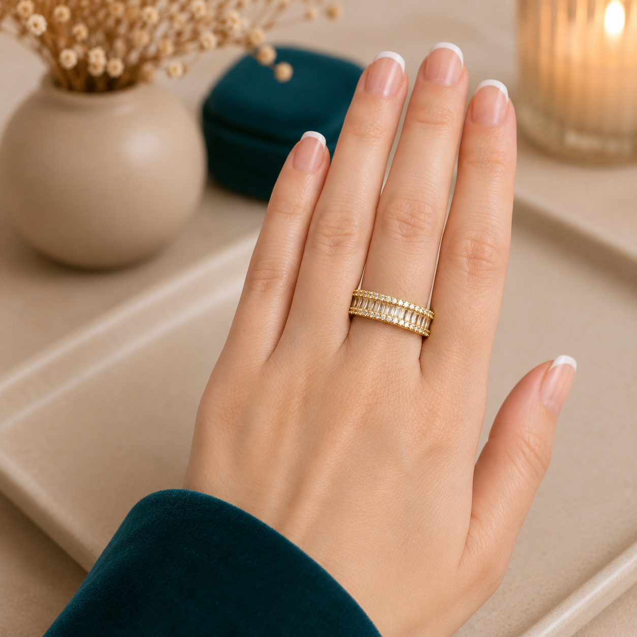 Gold adjustable baguette crystal statement band worn on a hand with a teal velvet sleeve in a luxury neutral setting.