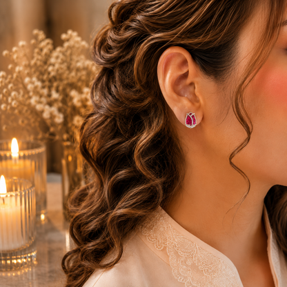 Woman wearing tulip crystal stud earrings in a luxury close-up portrait with soft curls, ivory-peach outfit, warm candlelight and dried floral background