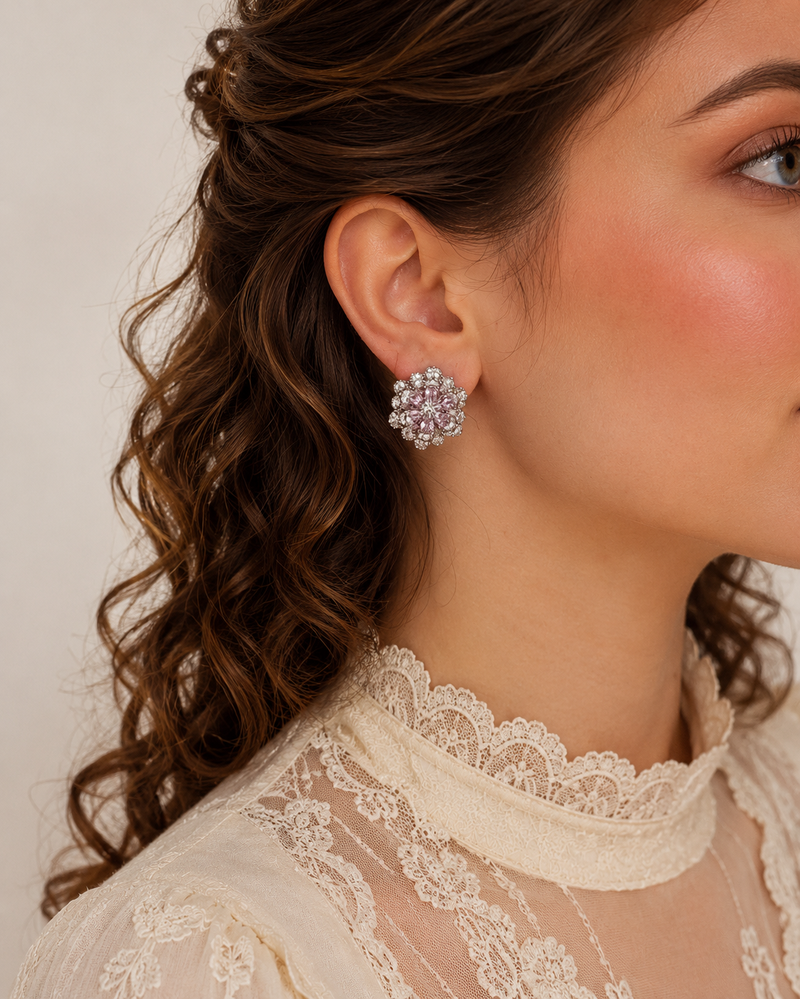 Blush pink floral crystal stud earrings worn by model, sparkling flower stud earrings with pink stones and silver accents.