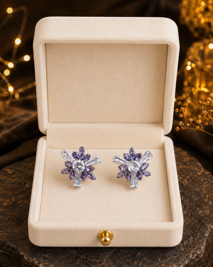 Lilac crystal floral stud earrings displayed inside a premium ivory velvet jewelry box with warm ambient lighting, showcasing luxury statement earrings.