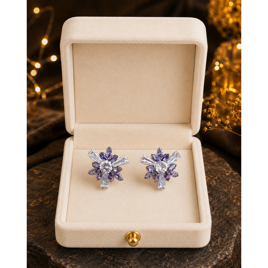 Lilac crystal floral stud earrings displayed inside a premium ivory velvet jewelry box with warm ambient lighting, showcasing luxury statement earrings.
