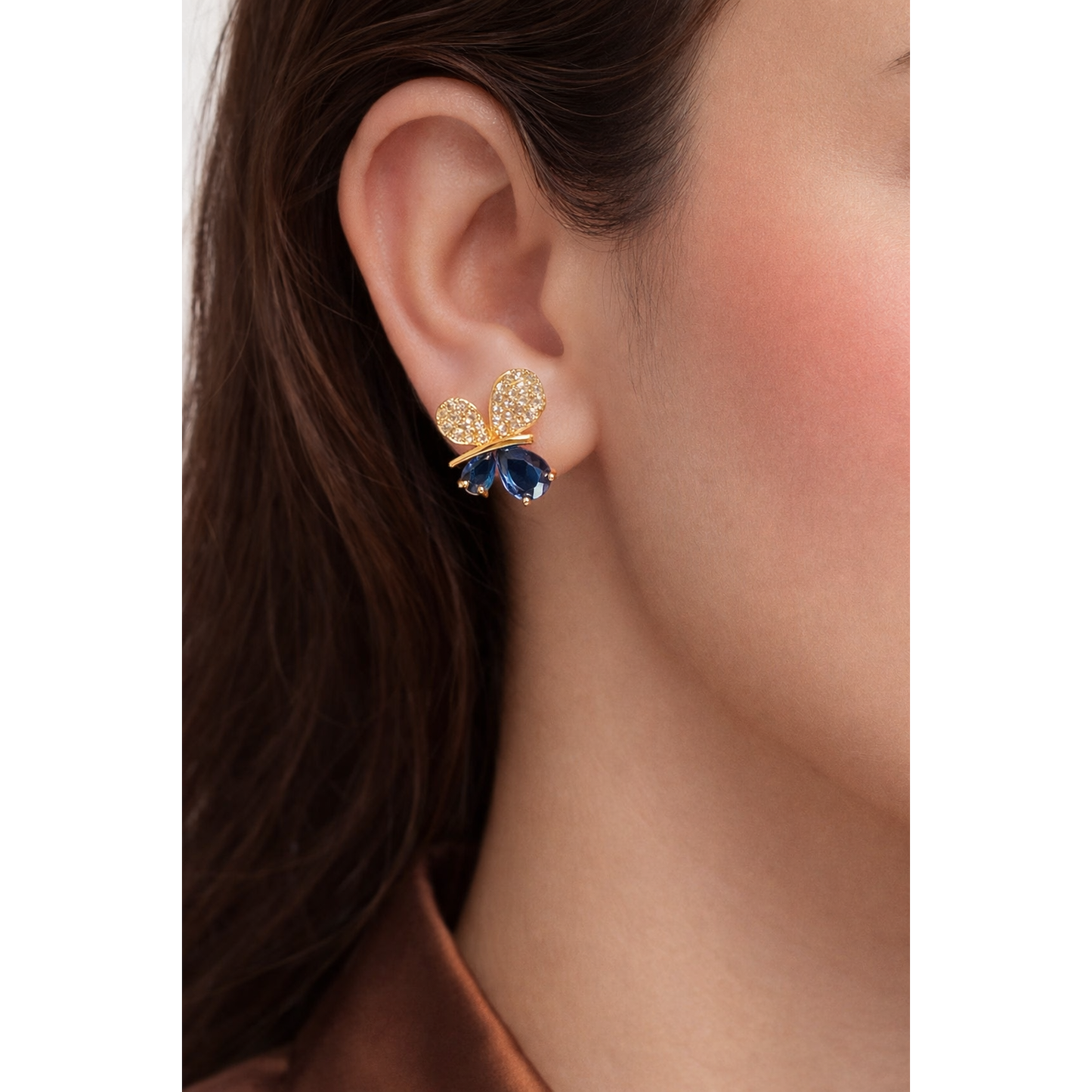 Close-up of Gold/Blue butterfly stud earrings  with pear-cut drop stones worn on ear, showing detailed wing texture and balanced drop size