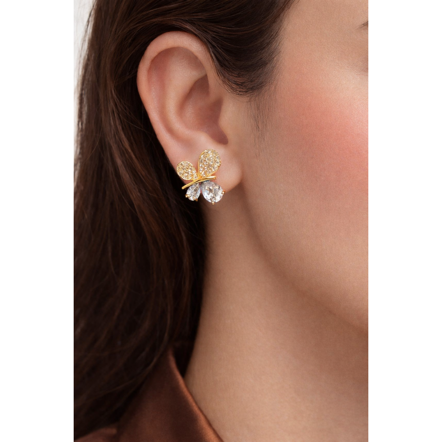 Close-up of Gold/Silver butterfly stud earrings with pear-cut drop stones worn on ear, showing detailed wing texture and balanced drop size