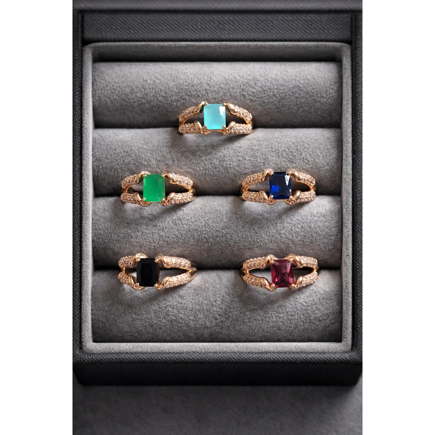 Adjustable square cut artificial stone ring in gold and silver variants displayed in a grey velvet jewelry box with multiple colour options including emerald green,  sapphire blue, pink, aqua and black stones
