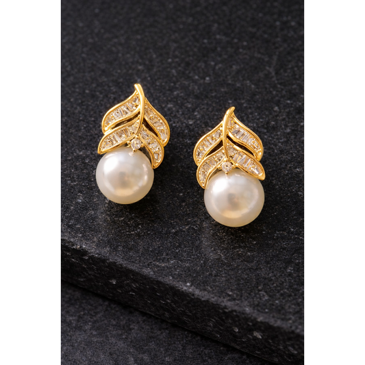 Gold leaf-design pearl zircon stud earrings displayed on black stone surface in high-definition