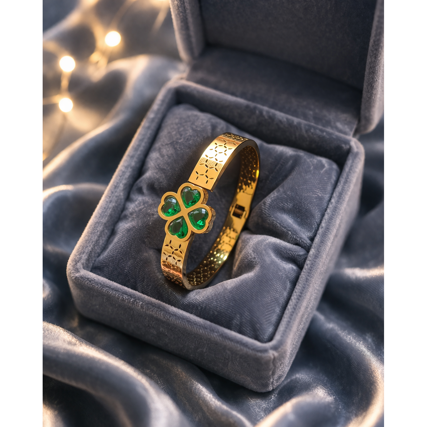 Gold bracelet with green clover stones placed in velvet jewelry box