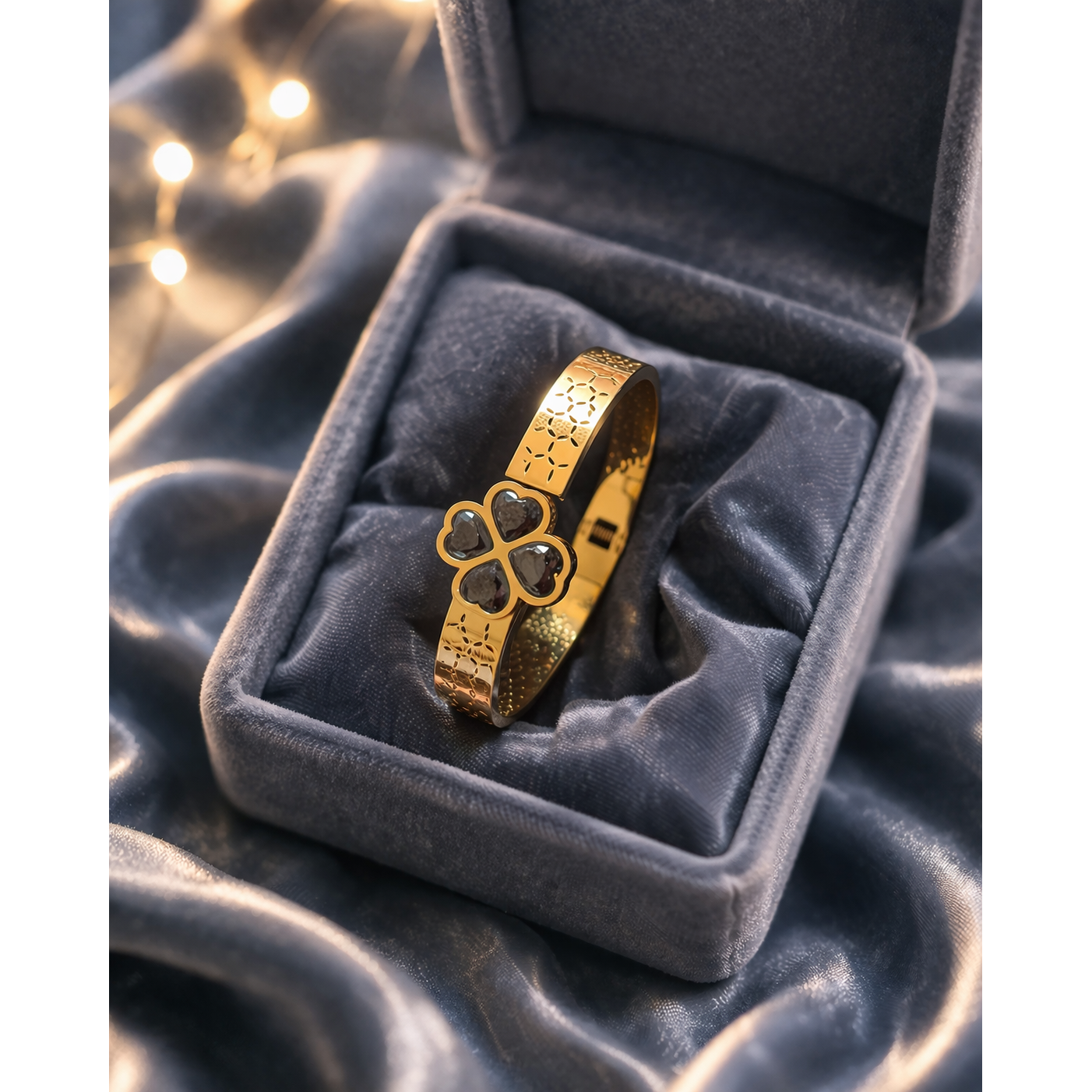 Gold bracelet with black clover stones placed in velvet jewelry box