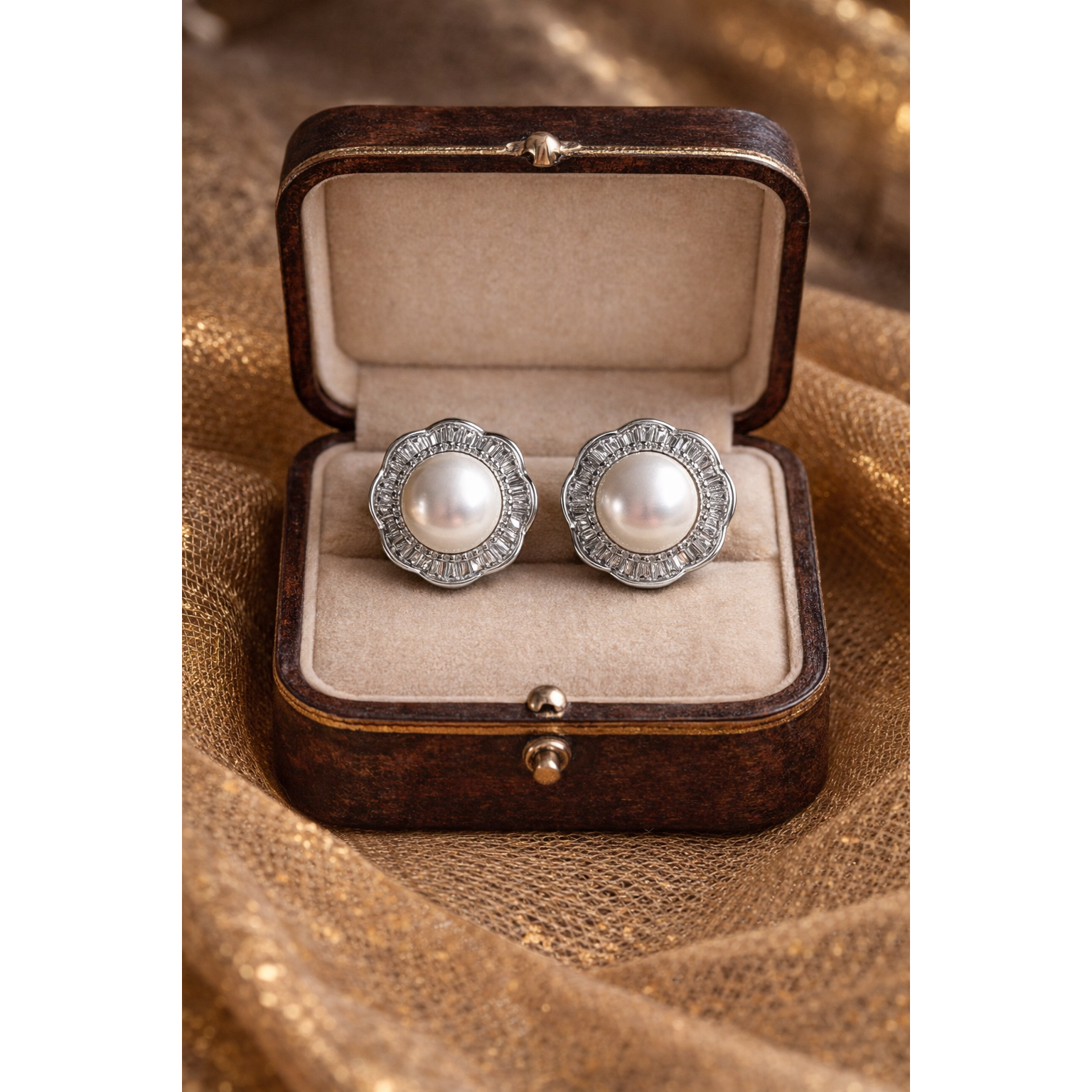 Silver pearl halo stud earrings displayed in antique wooden jewelry box on golden net cloth