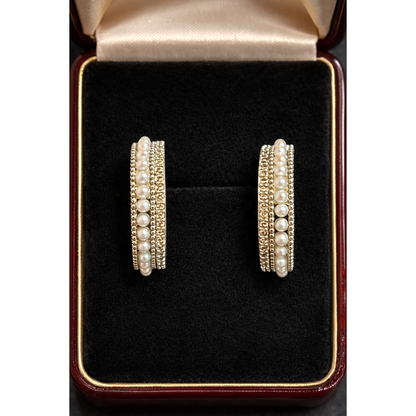 Pair of pearl row multi-band hoop earrings displayed inside a black velvet jewelry box showing layered design and beadwork texture