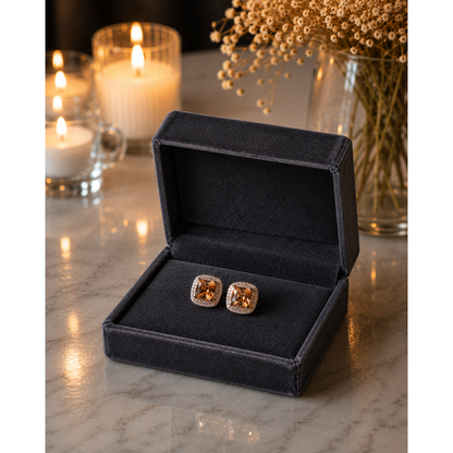 Gold-tone cushion-cut zircon stud earrings in champagne shade displayed in charcoal graphite velvet jewelry box