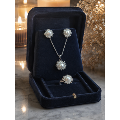 Silver pearl floral pendant necklace, earrings, and ring set displayed in premium navy velvet jewellery box with luxury studio lighting