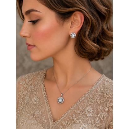 Woman wearing silver halo crystal pendant necklace and matching stud earrings with champagne beige embroidered outfit in soft luxury portrait styling