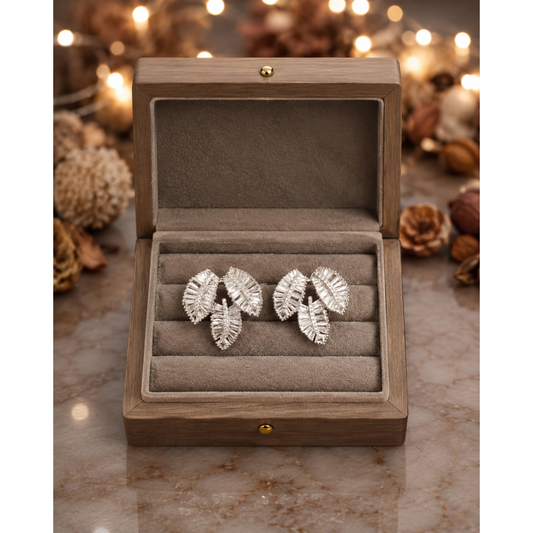 Silver crystal leaf cluster stud earrings showcased in a luxury taupe velvet jewelry box with premium presentation.