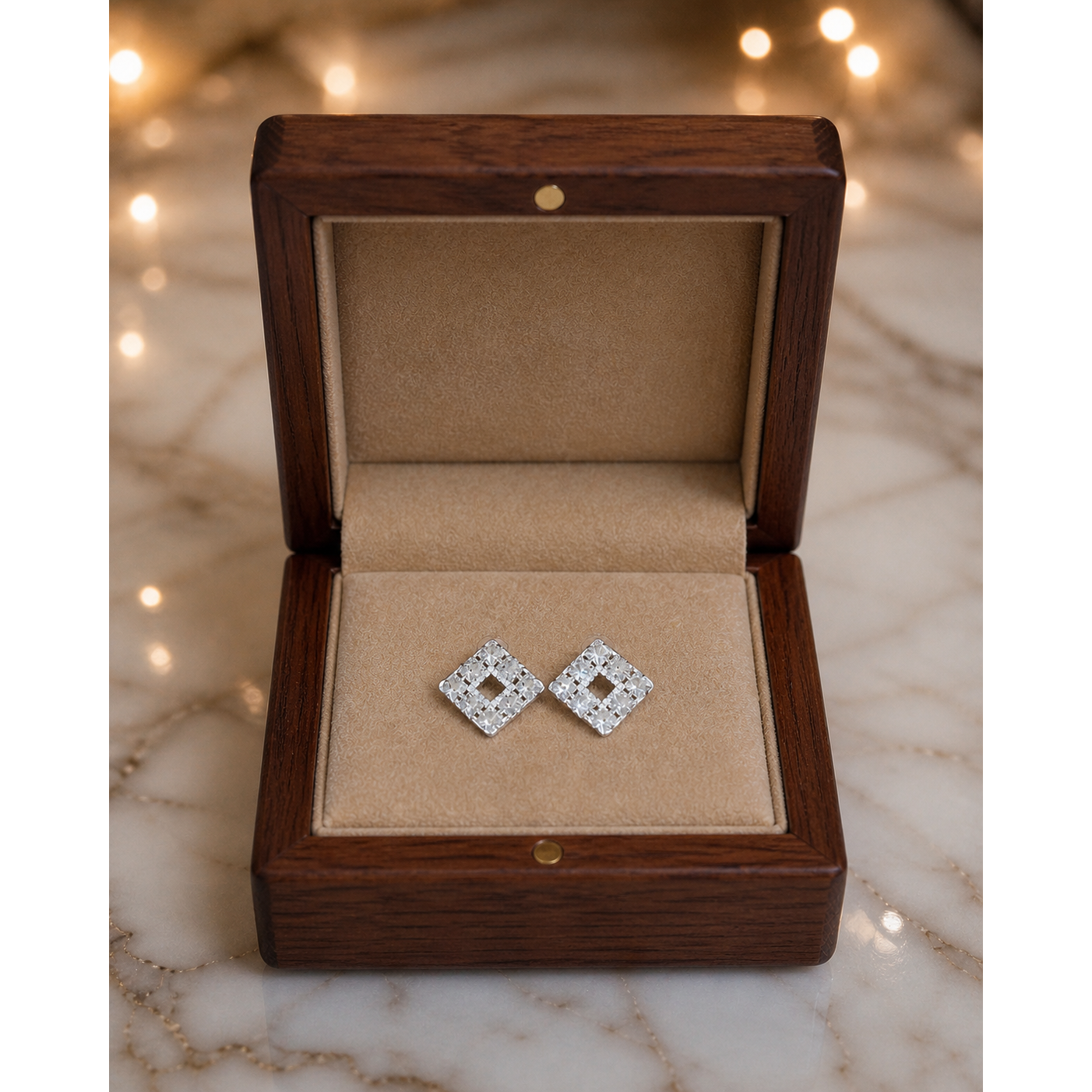 Silver square crystal stud earrings placed flat in wooden jewelry box with fawn velvet interior on marble surface