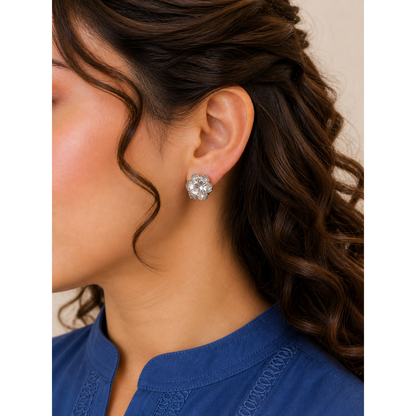 Silver floral crystal stud earrings worn on ear with round center stone and petal design