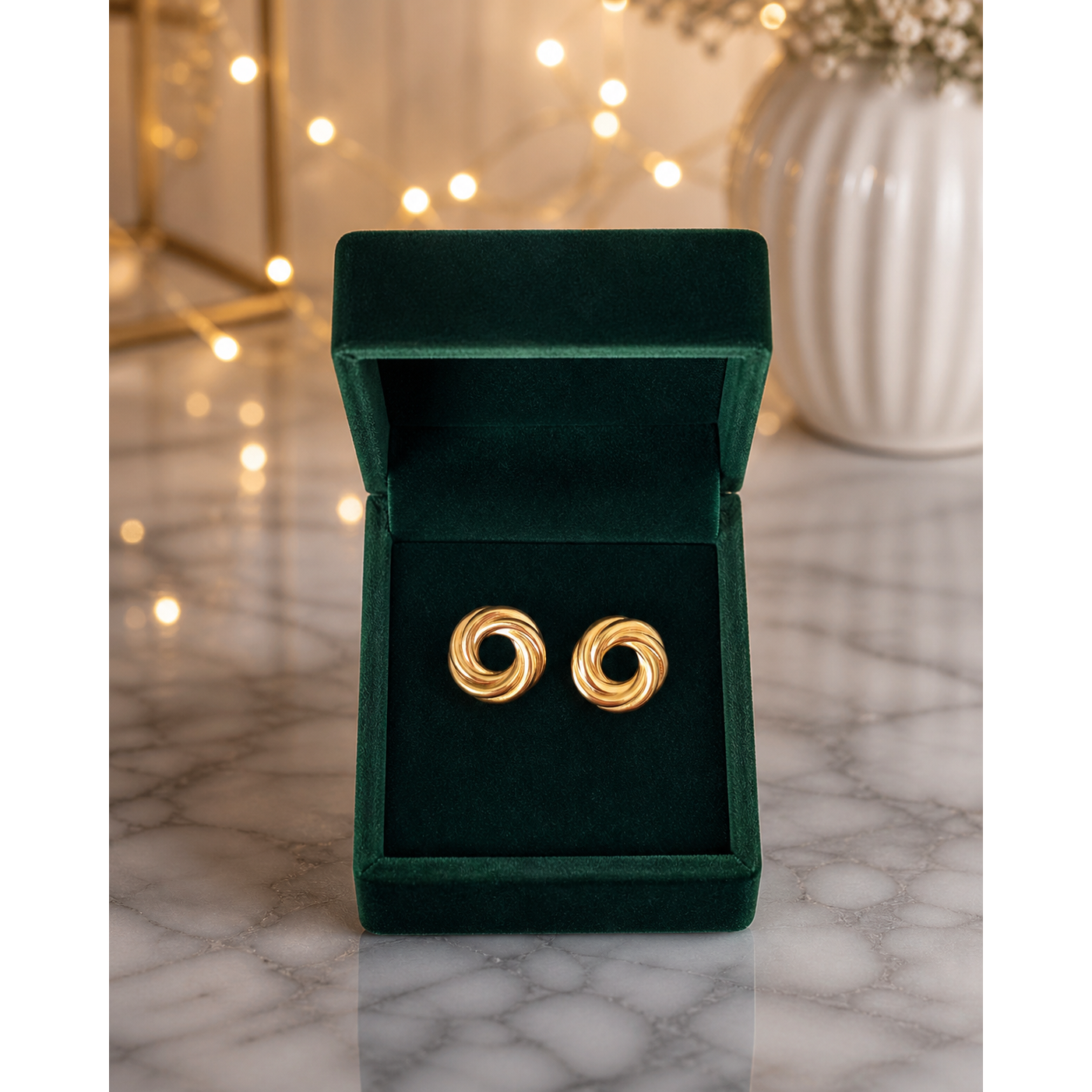 Gold swirl stud earrings placed in deep emerald velvet jewelry box on marble surface with soft lights