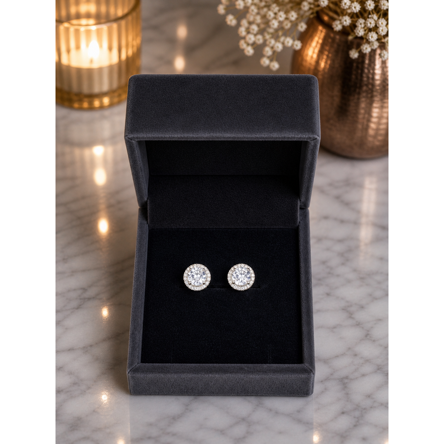Round crystal stud earrings placed in charcoal grey velvet jewelry box on marble surface with soft lighting