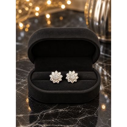 Silver flower stud earrings displayed in matte black oval velvet jewelry box on black marble with fairy lights background