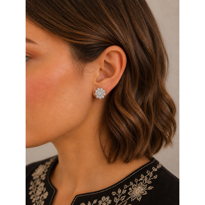Silver floral cluster stud earrings worn on ear with short brown wavy hair side profile close-up