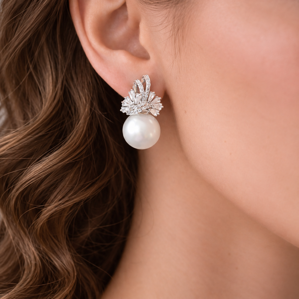 Close-up of model wearing Gilded Fan Pearl Drop earring featuring a crystal fan design and large white pearl.