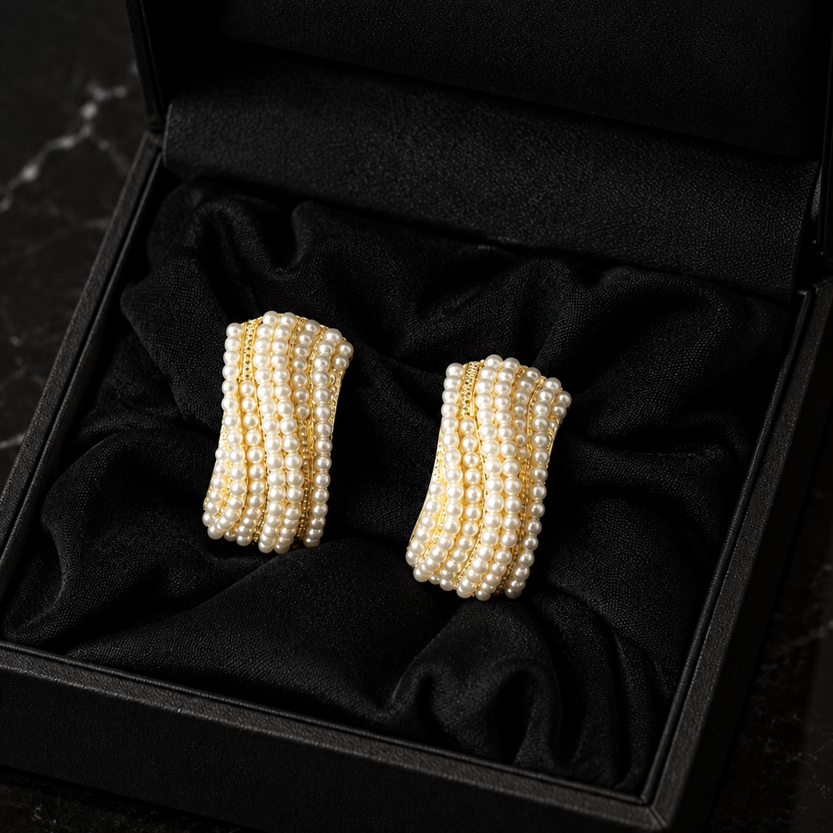 Pearl Ripple Stud Earrings featuring multiple curved rows of petite white pearls with fine gold-tone detailing, displayed in a black jewellery box.
