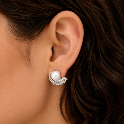 Close-up of Swan Arc Stud worn on the ear, featuring a luminous pearl and curved zircon-studded silver-tone swan silhouette.