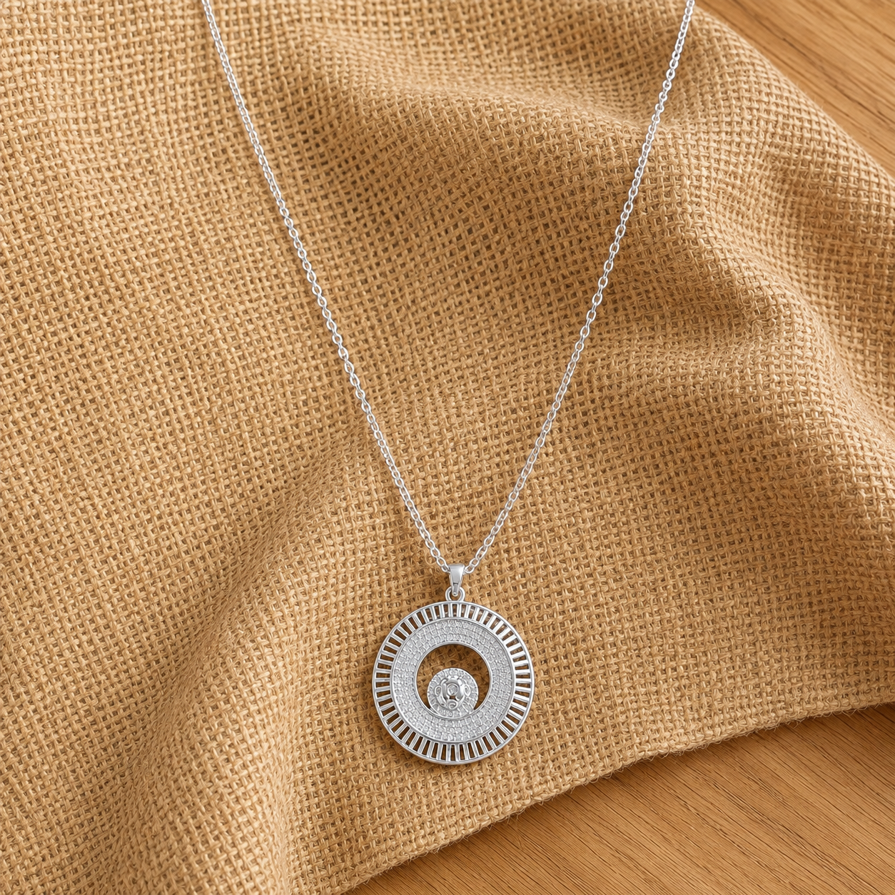 Silver-tone Inner Orbit Pendant with layered circular detailing, clear stones and a suspended centre motif on a fine chain.
