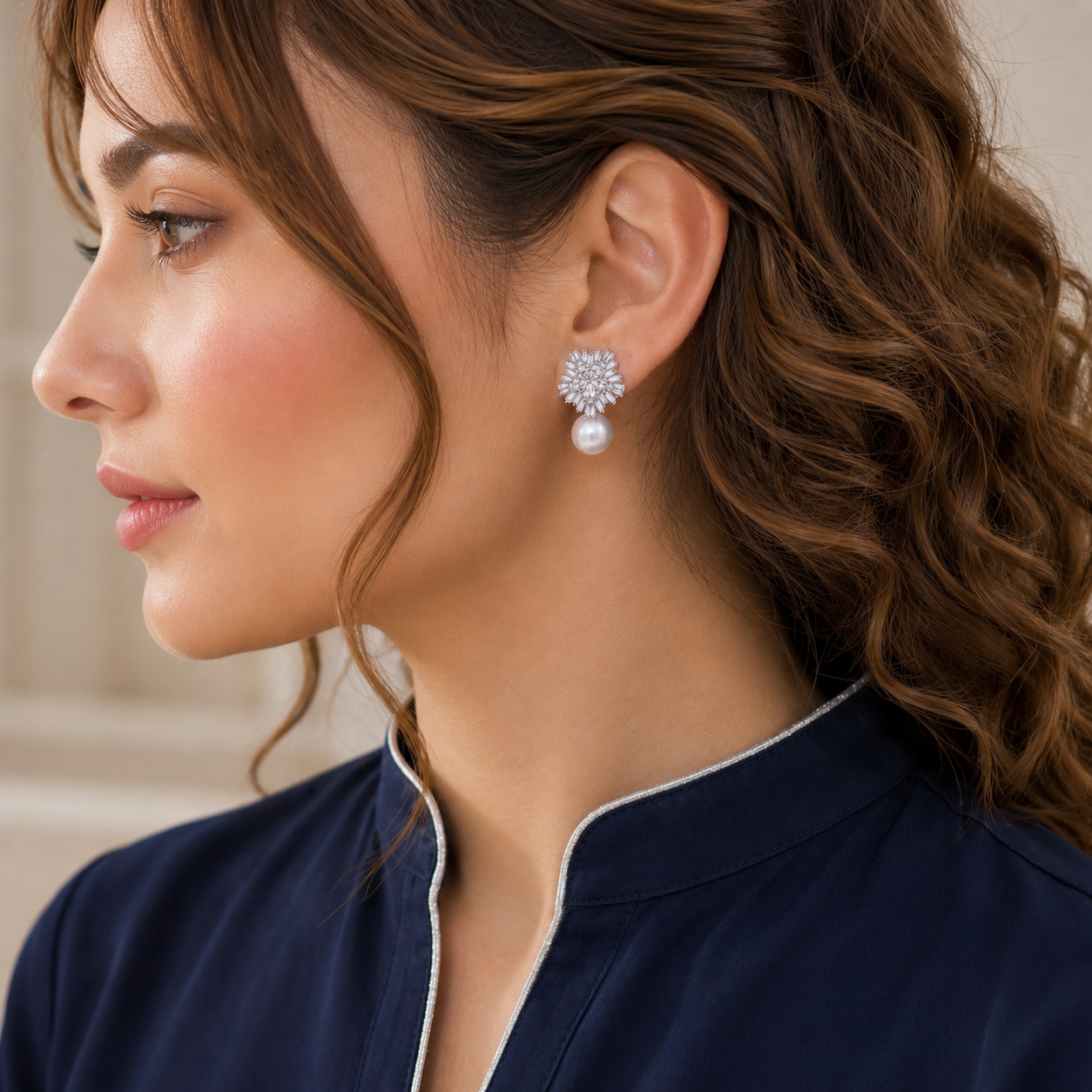 Zircon floral cluster earrings with luminous pearl drops worn on the ear by a model
