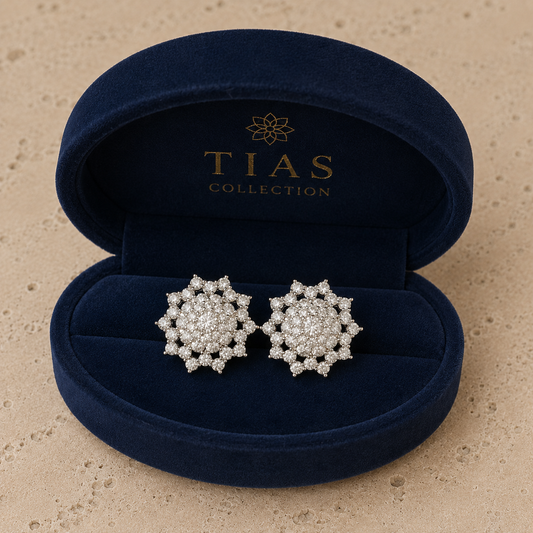 Pair of Astra Crest clear zircon cluster stud earrings displayed in a box