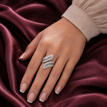 Virelle silver-tone leaf ring worn on the finger, showing its layered clear zircon leaves and sculptural wrap-style design