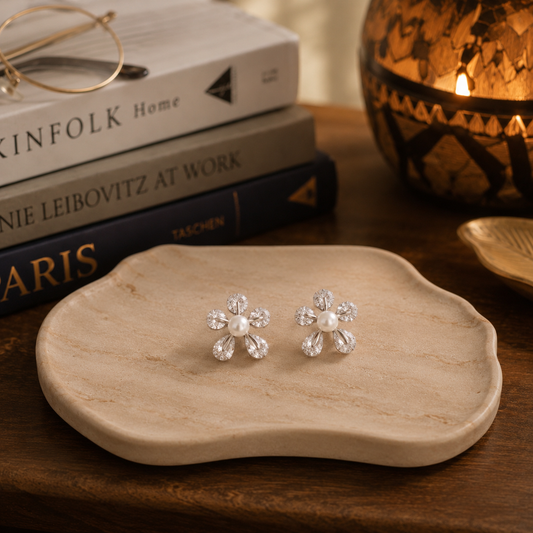 Elegant floral zircon and pearl earrings showcased on a  plate