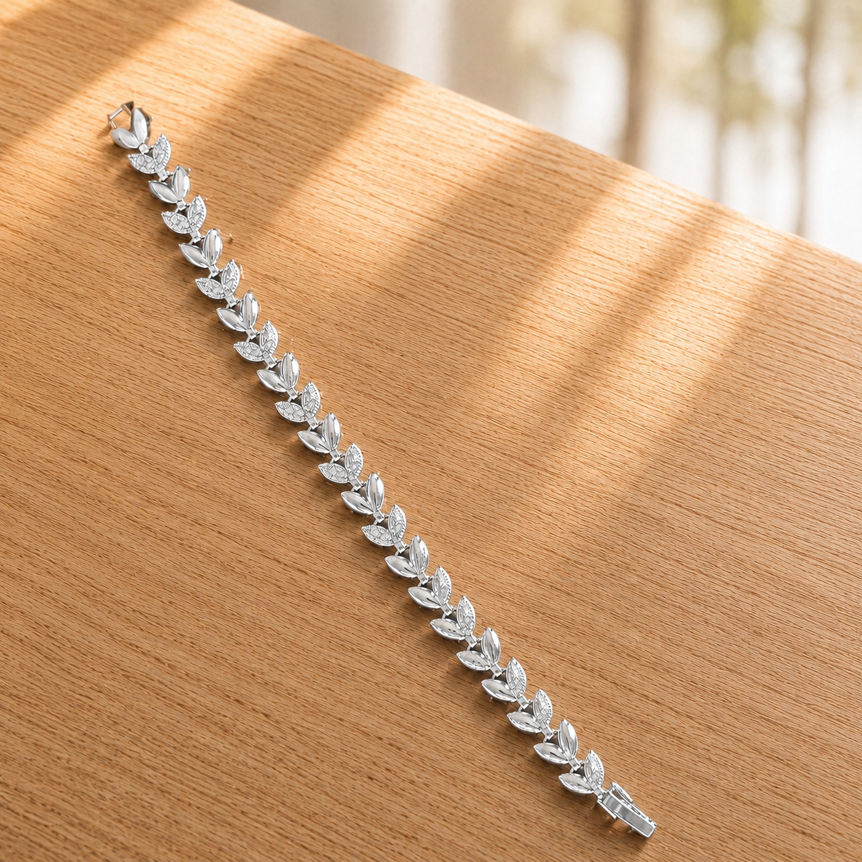 Close-up of Silver Sylvan Bracelet displayed straight , showing polished leaf links and clear zircon detailing.