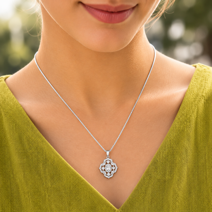 Model wearing a small silver-tone  clear stone locket with clear zircon accents against a deep plum outfit.