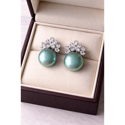 High-definition product photo of floral crystal and green pearl earrings displayed inside a premium velvet jewelry box