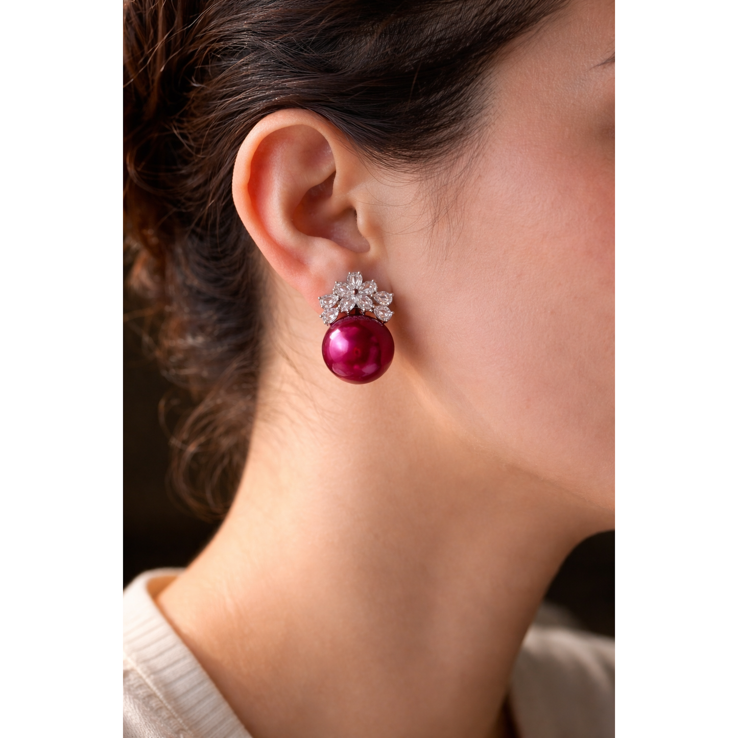Close-up of a model wearing elegant floral crystal and pearl earrings