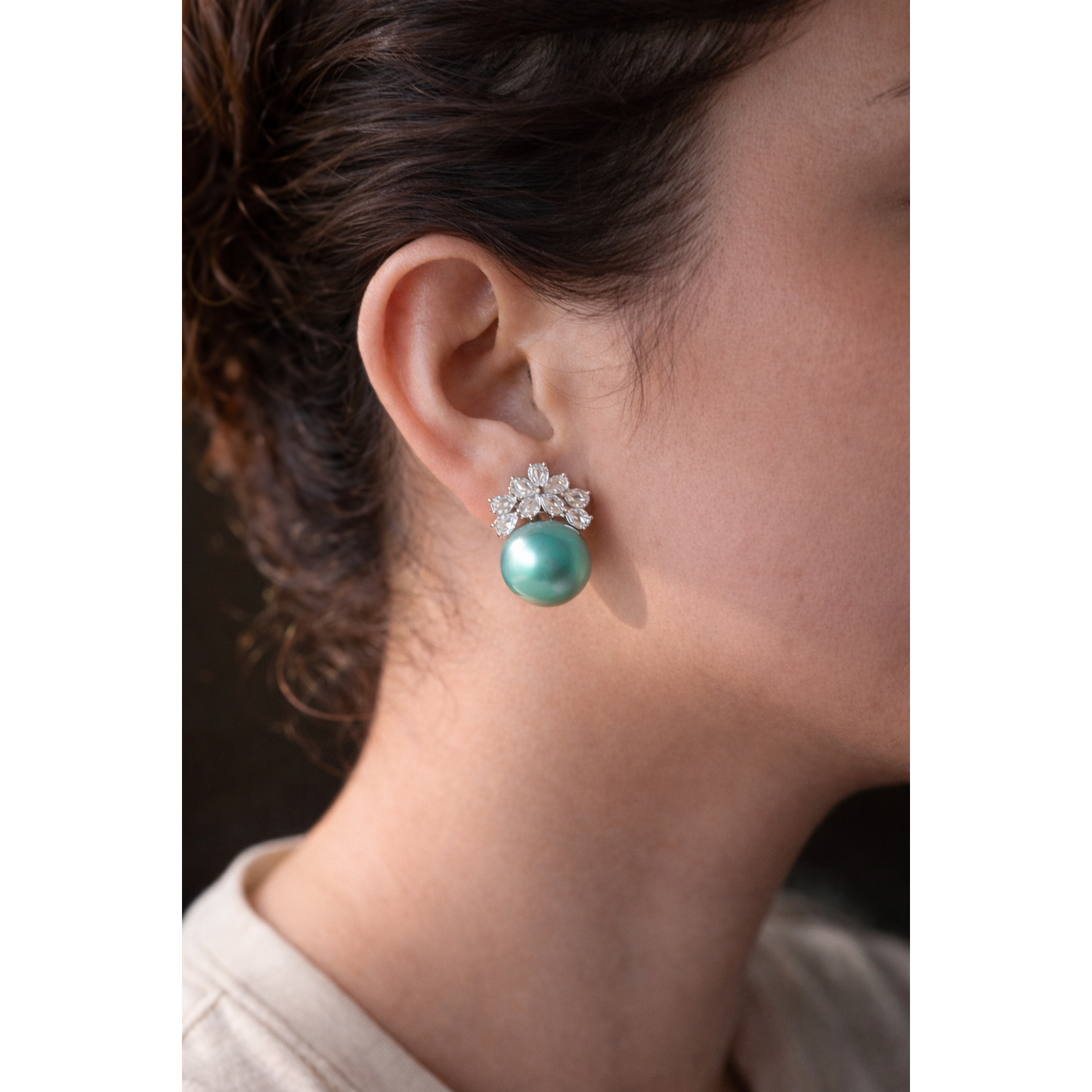Close-up of a model wearing elegant floral crystal and pearl earrings