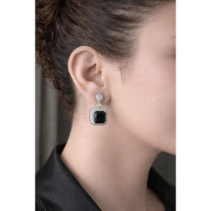 Silver square drop earrings with black stone worn by model close-up, modern geometric statement jewellery